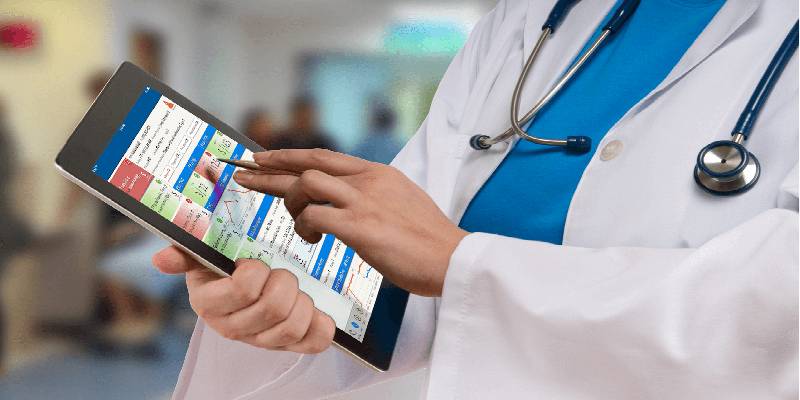 A medical professional holding a mobile device and accessing a medical app.