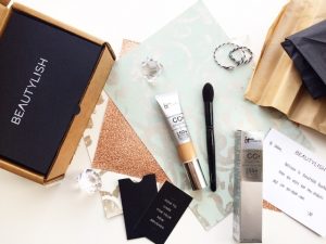 Make up brushes and creams displayed on a table with a box written as Beautylish.