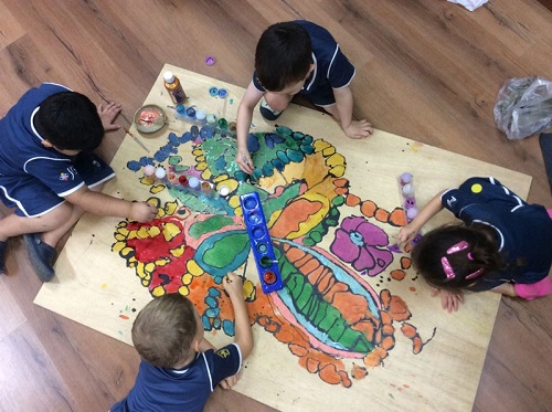 An image representing 4 children involved in creating an art
