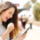 The image shows a teen girl holding her smart phone in a happy manner.